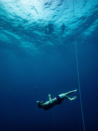 Shirtless man swimming in sea