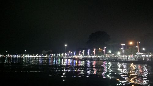 Illuminated sea against sky at night