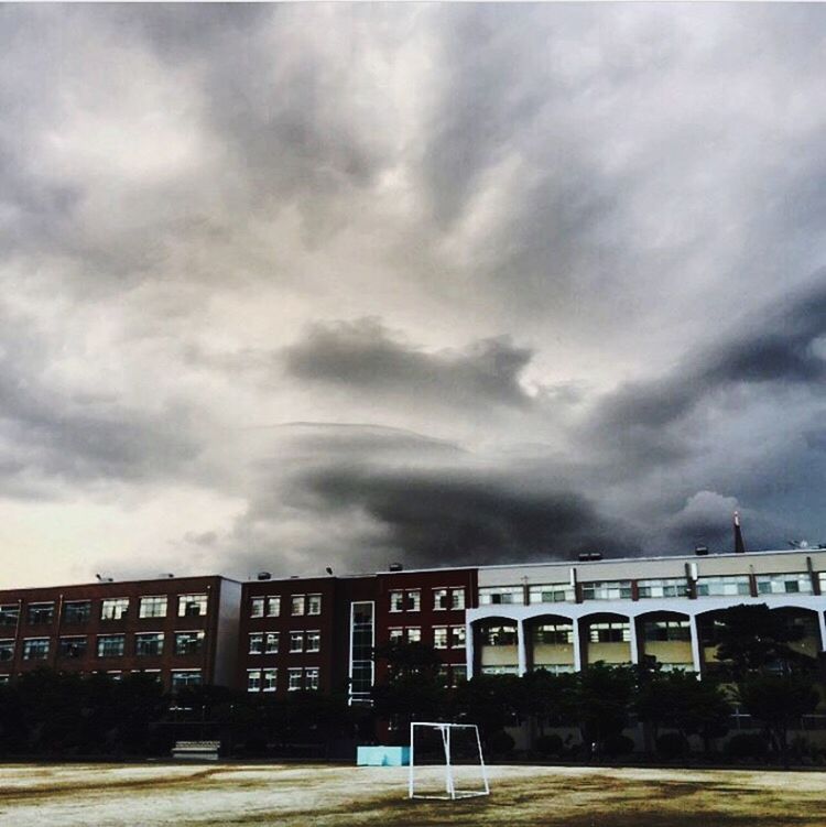 sky, cloud - sky, cloudy, text, built structure, architecture, western script, building exterior, weather, overcast, cloud, communication, railing, transportation, outdoors, day, information sign, storm cloud, road, graffiti