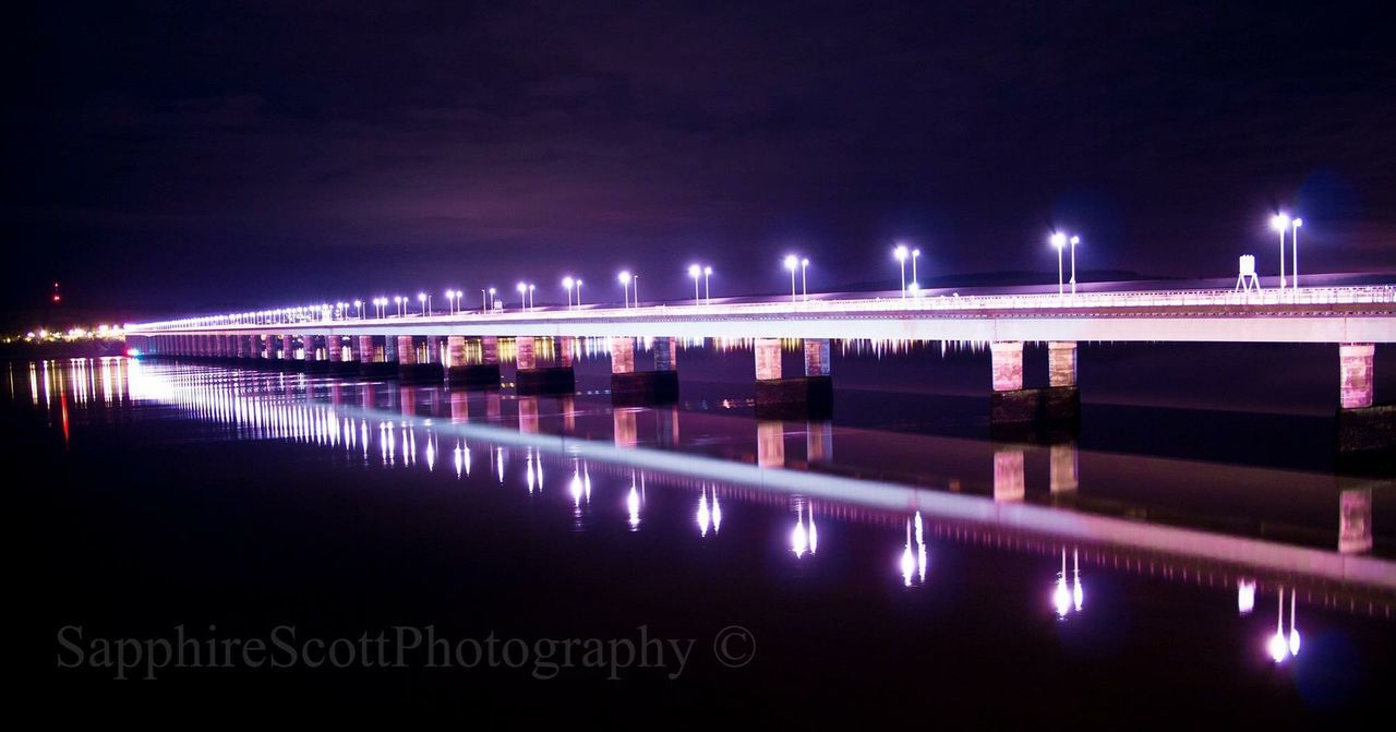 illuminated, night, water, reflection, built structure, waterfront, architecture, lighting equipment, river, pier, sea, sky, street light, city, building exterior, light, bridge - man made structure, light - natural phenomenon, outdoors, mid distance