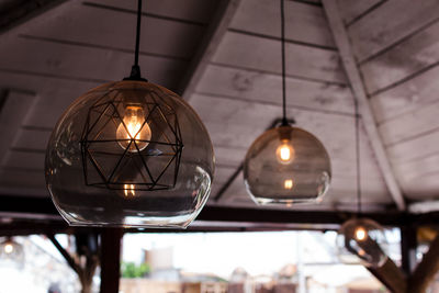 Close-up of illuminated pendant lights hanging from ceiling