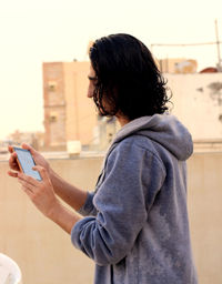 Side view of woman using mobile phone