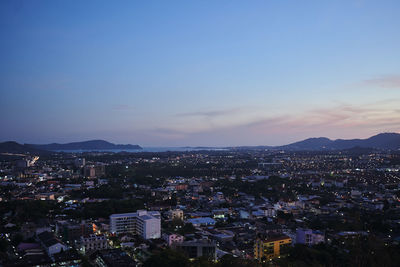 High angle shot of illuminated cityscape against sky at dusk