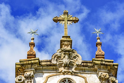 Low angle view of statue against building against sky