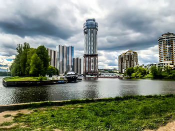 River by buildings in city against sky