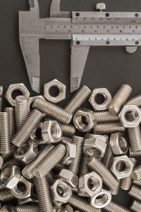 High angle view of nuts and bolts with ruler on table