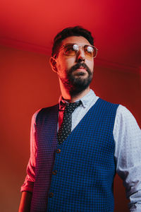 Portrait of young man against red background