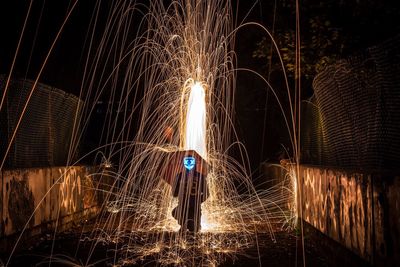 Man standing in front of illuminated light painting at night