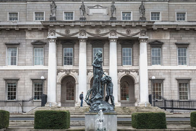 Statue against building in city