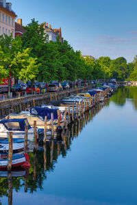 Boats moored in river against sky