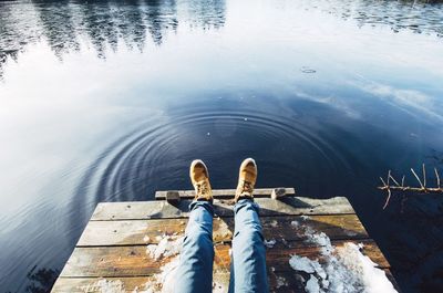 Man relaxing on pier over lake