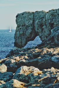 Rocks in sea against clear sky