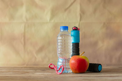 Close-up of apples in glass on table against wall