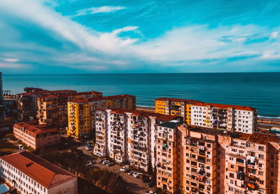 High angle view of buildings by sea against sky