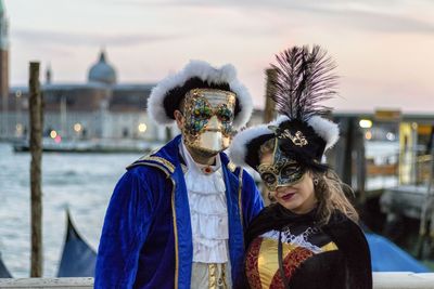 Man wearing mask against sky in city