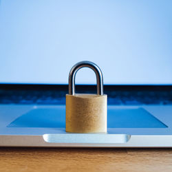 Close-up of padlock on laptop at table