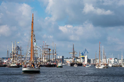 Sailboats in harbor against sky