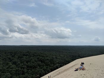 People at beach against sky