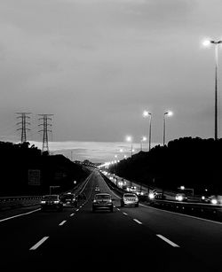 Cars on road against sky in city