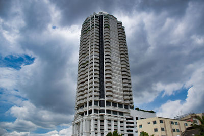 Low angle view of buildings against cloudy sky