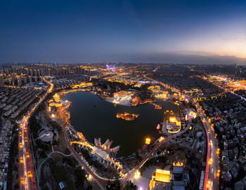 High angle view of illuminated cityscape against sky at night