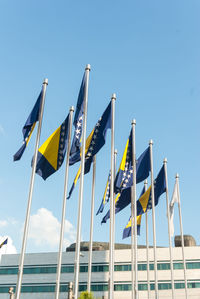 Low angle view of flags against blue sky