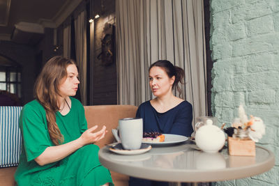 Two women talking and drinking coffee in cafe