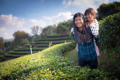 Woman standing by plants on field