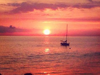 Boat sailing in sea at sunset