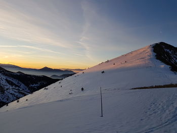 Scenic view of snowcapped mountains against sky during sunset