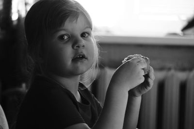 Close-up portrait of girl eating at home