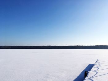 Scenic view of frozen lake against clear blue sky