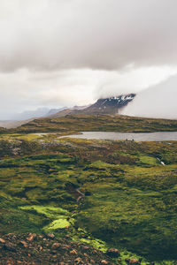 Scenic view of lake and mountains against cloudy sky