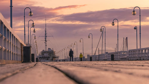 Surface level of street against sky during sunset