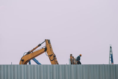 People working on construction site against clear sky