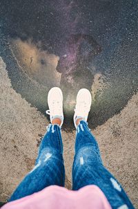 Low section of woman standing on puddle