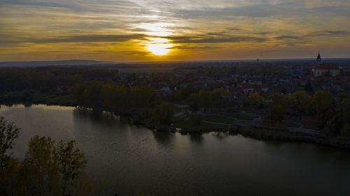 High angle view of river and cityscape against sky at sunset