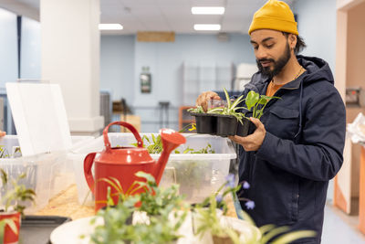 Male customer wearing jacket while buying plants at recycling center