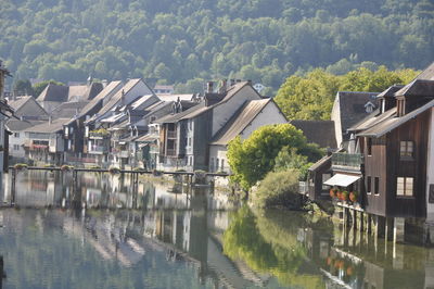 Houses by river amidst buildings in city