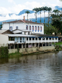 Building by river against sky in city