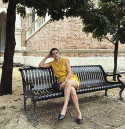 Young woman sitting on bench in park