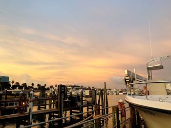 Boats moored at harbor during sunset