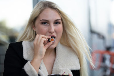 Portrait of beautiful young woman eating food