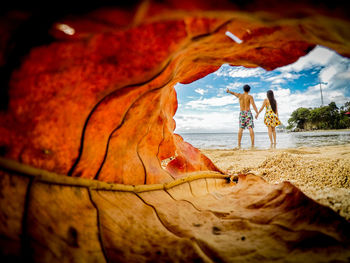 People at beach against sky