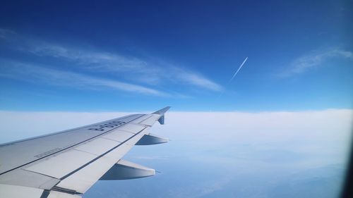 Aerial view of airplane wing against sky