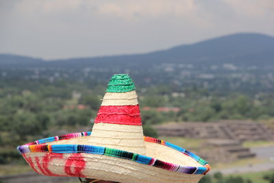 Close-up of multi colored hat on land against sky