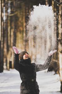 Woman throwing while playing with snow