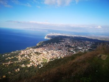 High angle view of townscape by sea against sky