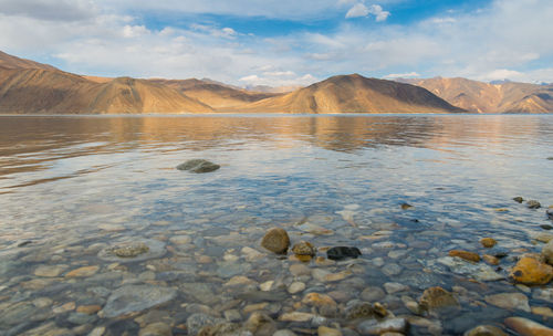 Scenic view of sea and mountains against sky