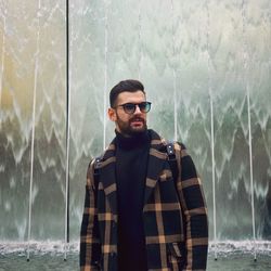 Portrait of young man wearing sunglasses standing outdoors